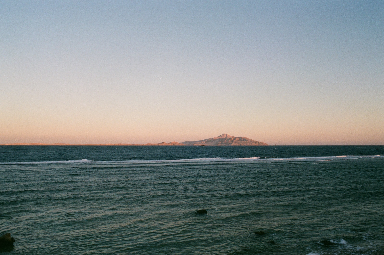 a large body of water with a small island in the distance